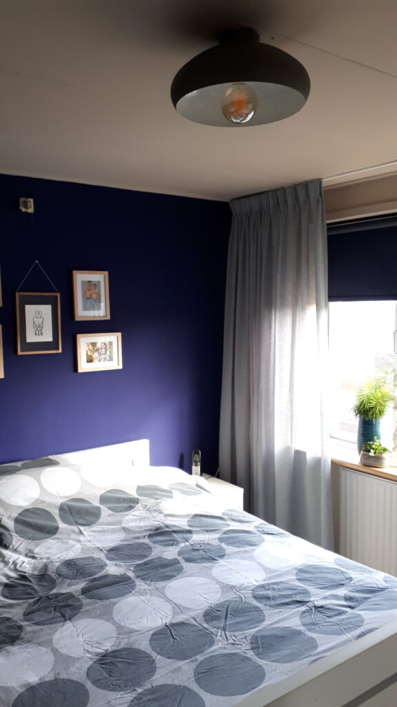 Laura's HI Design slaapkamer masterbedroom bed nachtkastje fotomuur foto photowall kunst plant groen rolgordijn vensterbank vitrage blauw donkerblauw beige mint armatuur lamp wit bruin interieur